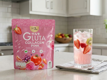 A pink stand-up pouch of Morphe Gluta Collagen Pink dietary supplement stands on a kitchen counter next to a glass of pink collagen drink with strawberries, kiwi, and ice, with a blurred kitchen background.