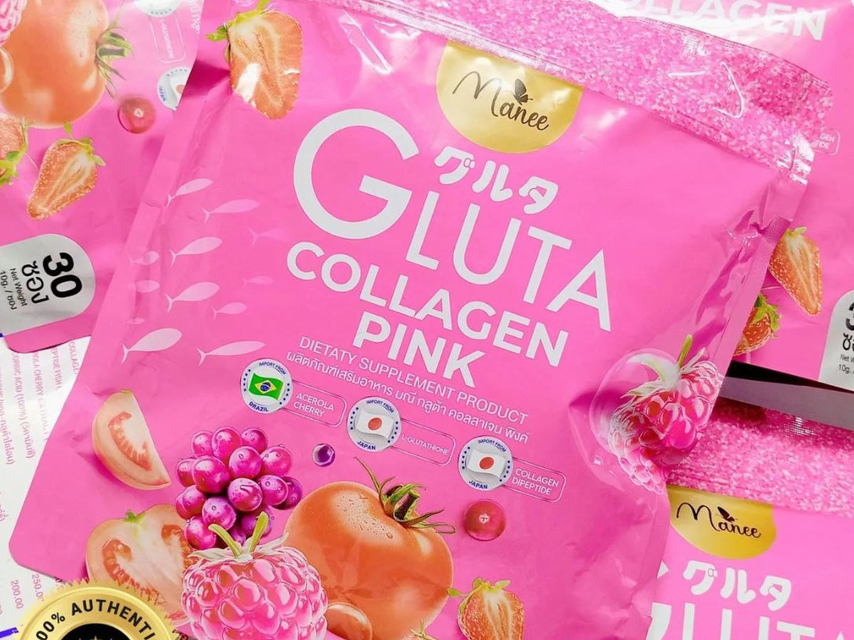 A close-up of a pink Manee Gluta Collagen Pink bag with fruit illustrations, shown alongside other matching bags on a light surface.